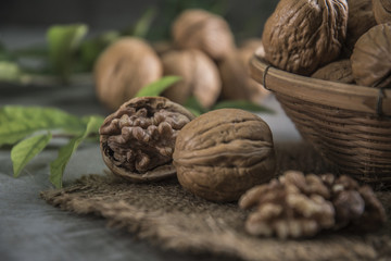 Walnuts in wooden bowl. Whole walnut on table