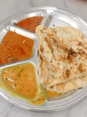 Roti canai, served with dal and curry. It is also known as roti cane or roti prata, an Indian-influenced flatbread dish found in several countries in Asia.