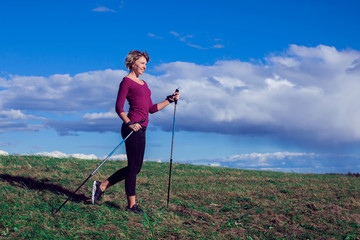 Nordic walking, exercise, adventure, hiking concept -a woman hiking in the nature
