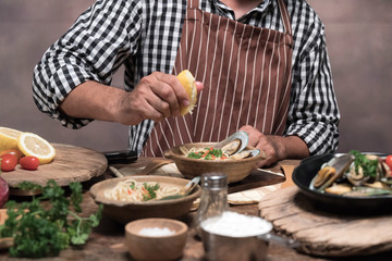 Handsome bearded cheef cook prepairing spaghetti on a kitchen.