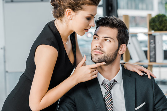 young seductive businesswoman flirting with colleague in office