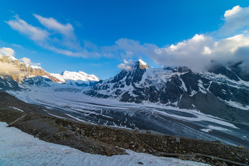 Fototapeta premium Scenic view of beautiful landscape of Swiss Alps with a majestic Glacier de Corbassiere, Switzerland. Dramatic sunset scene in high mountains.