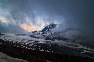 Obraz premium Dramatic sunset scene in high mountains. Clouds covering high peaks of Valais Alps (Pennine Alps), Switzerland in a evening light.