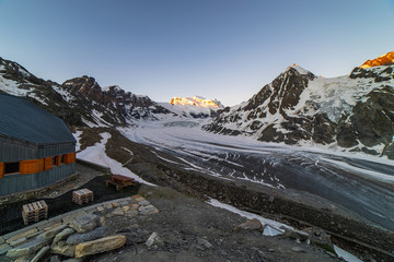 Obraz premium Scenic view of beautiful landscape of Swiss Alps with a majestic Glacier de Corbassiere in a view, Switzerland. Clear sky sunrise in Valais Alps (Pennine Alps), Switzerland in a early morning light.