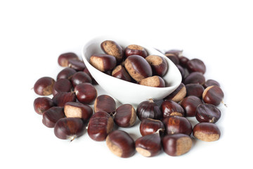 pile of chestnuts in a white bowl isolated