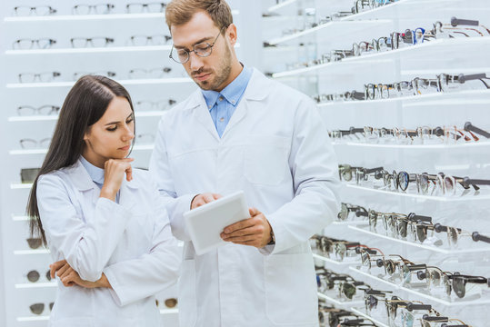 professional optometrists working and using digital tablet in ophthalmic shop