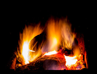 Bright burning firewood in the brazier, hot flame on a dark background, fire