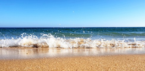 Waves crashing down on the beach in Porto de Mós, Lagos, Portugal 