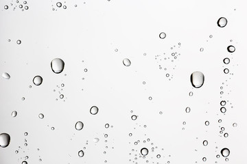 white isolated background water drops on the glass / wet window glass with splashes and drops of...