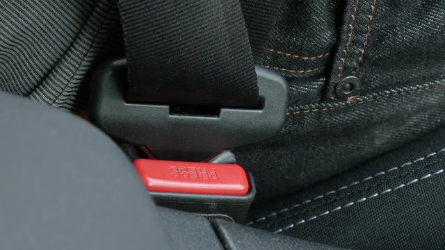 Driver fastens 3-point seat belt close-up 4K video