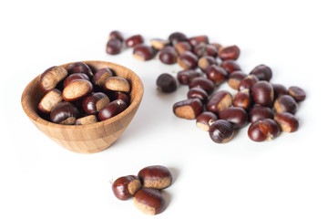 pile of chestnuts in a wooden bowl isolated
