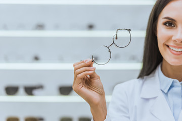 attractive smiling optometrist holding eyesight in optica