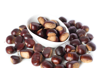 pile of chestnuts in a white bowl isolated
