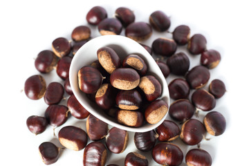 pile of chestnuts in a white bowl isolated
