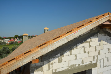 Roofing construction with trusses, wooden beams on new house building. Rooftop view.