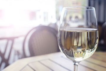 glass of white wine in the restaurant / white wine in the interior of the restaurant a table with glasses of wine, a romantic summer