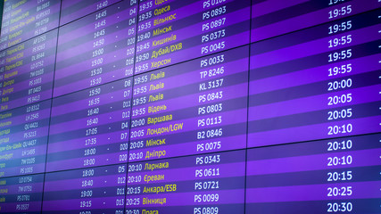 Big display with timetable of airplane flights in airport terminal
