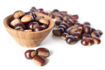 pile of chestnuts in a wooden bowl isolated

