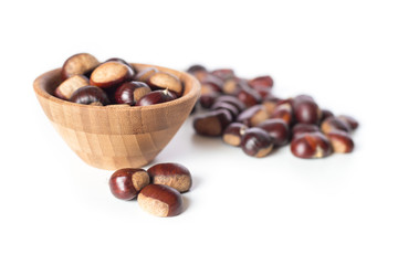 pile of chestnuts in a wooden bowl isolated
