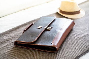 vintage dark leather handbag on brown and Hat weave background