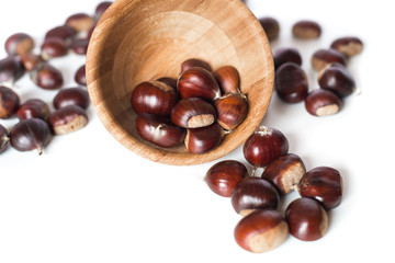 pile of chestnuts in a wooden bowl isolated
