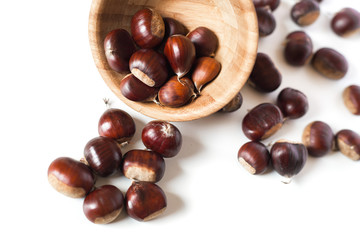 Obraz premium pile of chestnuts in a wooden bowl isolated 