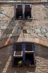 Fototapeta na wymiar Shuttered windows and flowerboxes on display in Siena, Italy