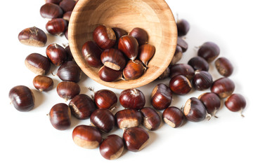 Obraz premium pile of chestnuts in a wooden bowl isolated 