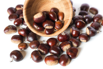 Obraz premium pile of chestnuts in a wooden bowl isolated 