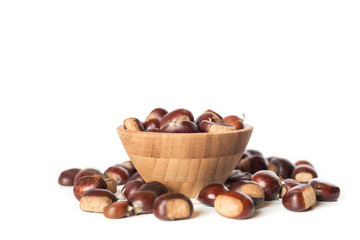 pile of chestnuts in a wooden bowl isolated
