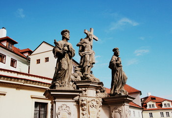 Statue of the Holy Savior with Cosmas and Damian on Charles Bridge in Prague, Czech Republic