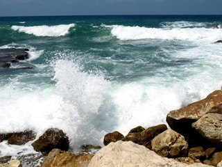 Fototapeta na wymiar Wave splashing against stones