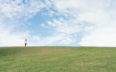 Fototapeta premium Woman standing on the mountain and looking beautiful sky.