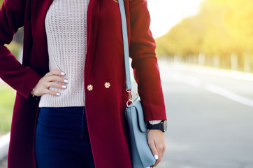 Beautiful woman female bag coat sweater jeans smile watch sunglasses in the street sun