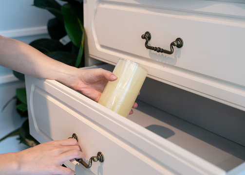 Hand Pull Open white Wooden Drawer. White aroma candle in hand.