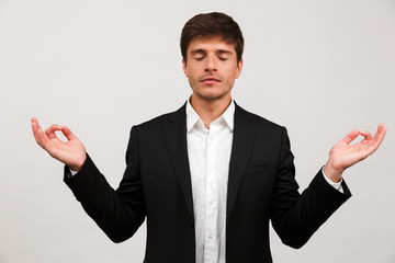 Businessman standing isolated over white background wall meditate.