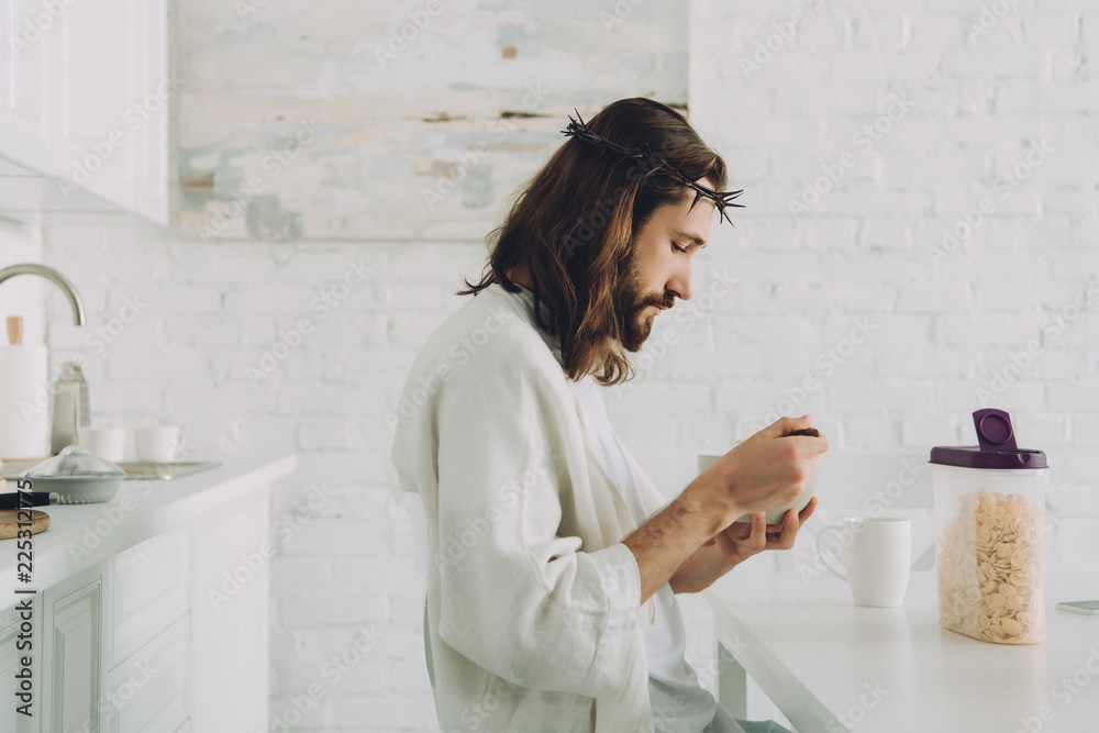 Wall mural side view of Jesus eating corn flakes on breakfast in kitchen at home