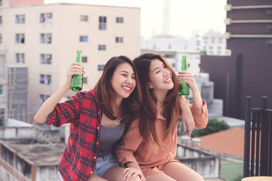 Two Asian Women Drinking At Rooftop Party, Outdoors Celebration, Friendship, LGBT Couple