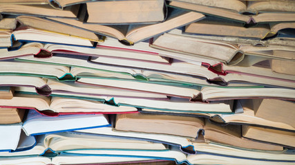 chaotic stack of old books background, selective focus