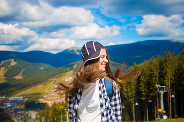 Happy tourist woman with fly hair on top of mountains, freedom and happiness concept