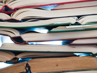 chaotic stack of old books background, selective focus