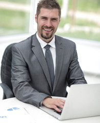 closeup.smiling businessman working with laptop