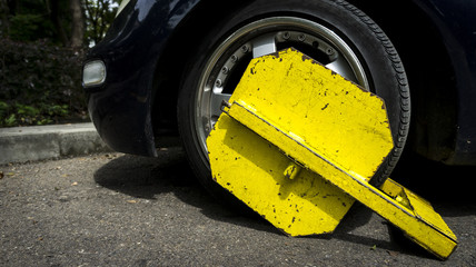 fitted bracket on an improperly parked car. attaching brackets to cars. tire clamp. control of...