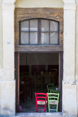 Fototapeta na wymiar Red and green chairs at a restaurant in Siena, Tuscany