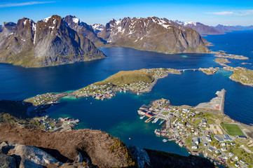 View from above of Reine village  on a small archipelago of Lofoten islands with mountain around it, Norway.