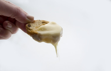 Detale de una mano sosteniendo un pan de pasas tostado con queso fundido 4