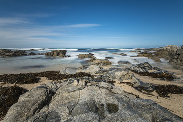 Fototapeta na wymiar Oceano Pacifico con rocce e cielo blu