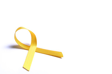Yellow ribbon - bladder, liver and bone cancer awareness symbol. Children cancer prevention association concept. Isolated background, copy space, close up, top view, flat lay