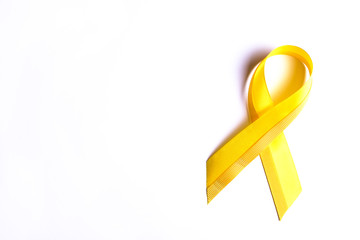 Yellow ribbon - bladder, liver and bone cancer awareness symbol. Children cancer prevention association concept. Isolated background, copy space, close up, top view, flat lay
