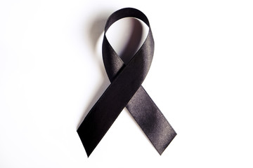 Black ribbon - sign of POW/MIA remembrance and mourning, melanoma awareness, sleep disorders and gang prevention symbol. Isolated on white background, copy space, close up, top view, flat lay.